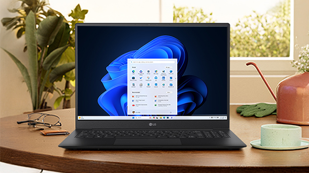 This image shows the laptop on a wooden desk surrounded by plants and lamps with a copy of "Easy to deploy, compatible, and cost-effective."