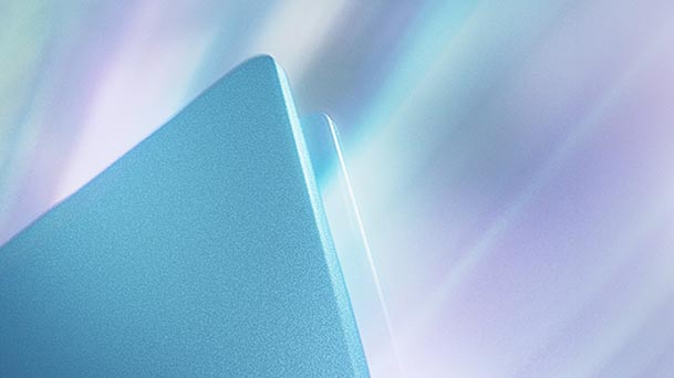 This image shows a close-up view of the sleek metallic edge of an laptop with a soft gradient light reflection.