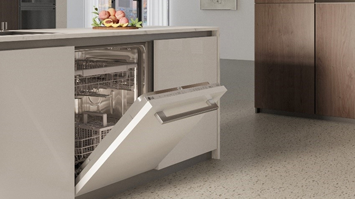 LG dishwasher with open door and visible racks, built into a light kitchen island with clean cabinetry and minimal design.