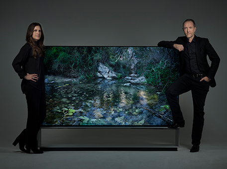 Artist duo Alexandrov Klum leaning on a LG SIGNATURE 88" TV