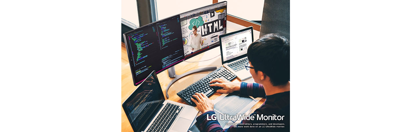 A computer programmer using the LG UltraWide Monitor with two laptops to multitask while working from home.