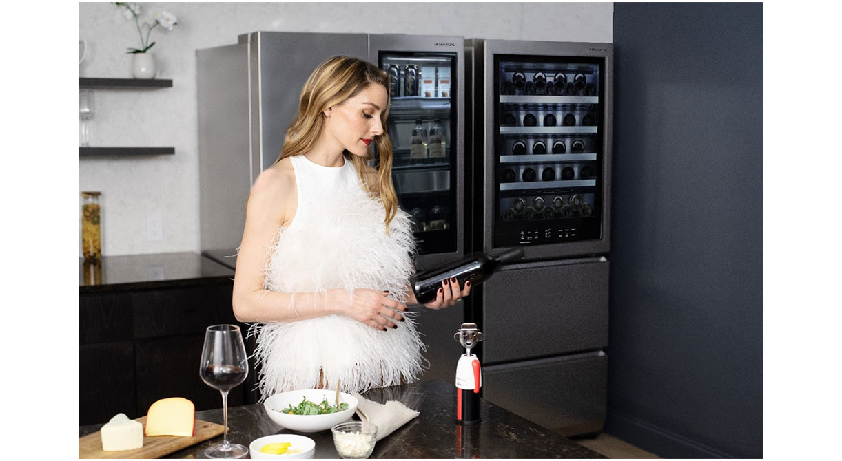 Olivia Palermo is pouring a glass of wine in front of the LG SIGNATURE InstaView™ Door-in-Door® Refrigerator.