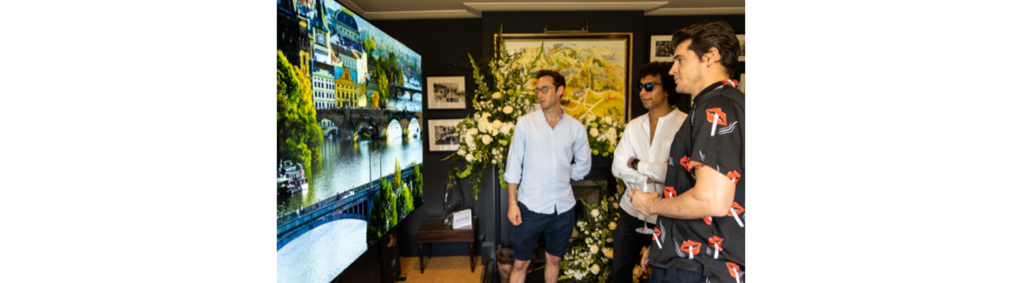 Three male attendees of SIGNATURE’s Goodwood event take a closer look at the clear, vivid imagery provided by the LG SIGNATURE 77-inch OLED TV