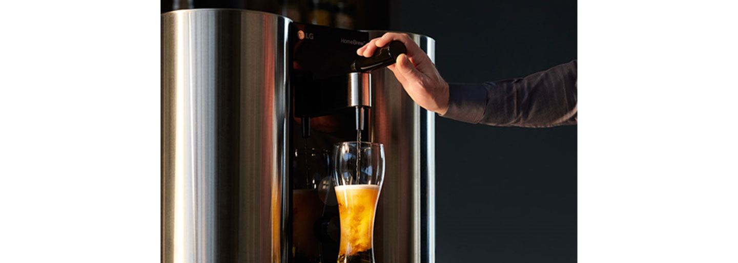 A man holds down the tap of LG HomeBrew to pour the perfect beer