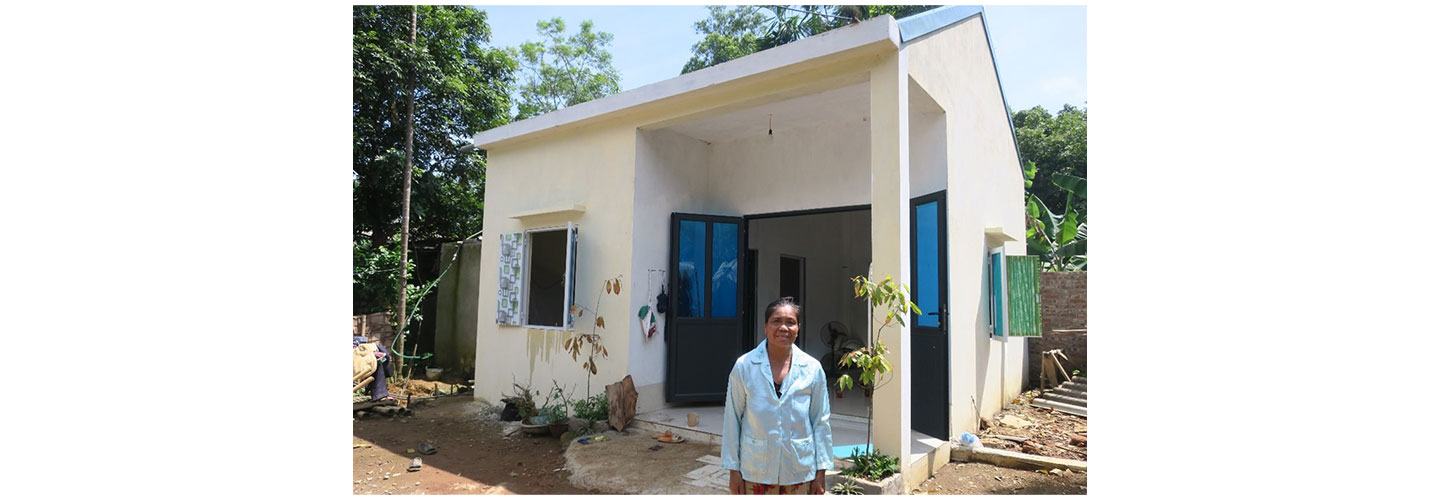Bui Thi Luc, a resident of the Ruong Denh village, posing in front of her house which was rebuilt through the Hope Village project