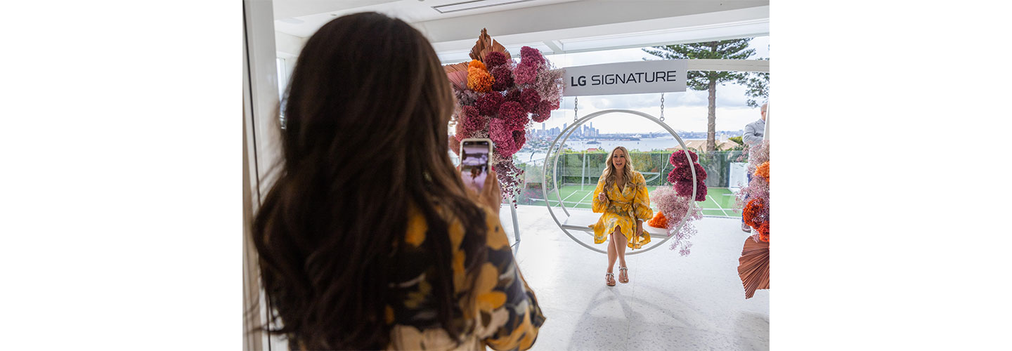Friends take photos during the LG SIGNATURE Home tour with the gorgeous Sydney skyline behind