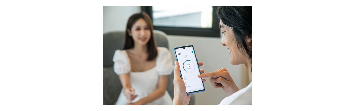 Man controlling LG appliance with LG ThinQ app on his smartphone. 