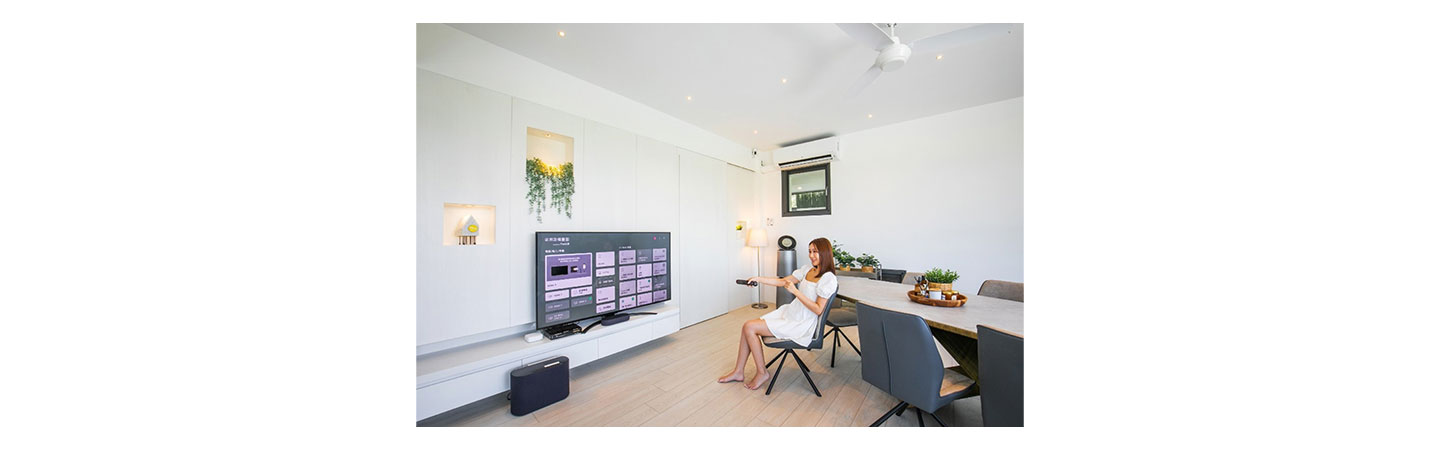 Woman browsing through TV channels with the remote inside the LG ThinQ One-Bedroom Pool Villa at The Westin Yilan Resort
