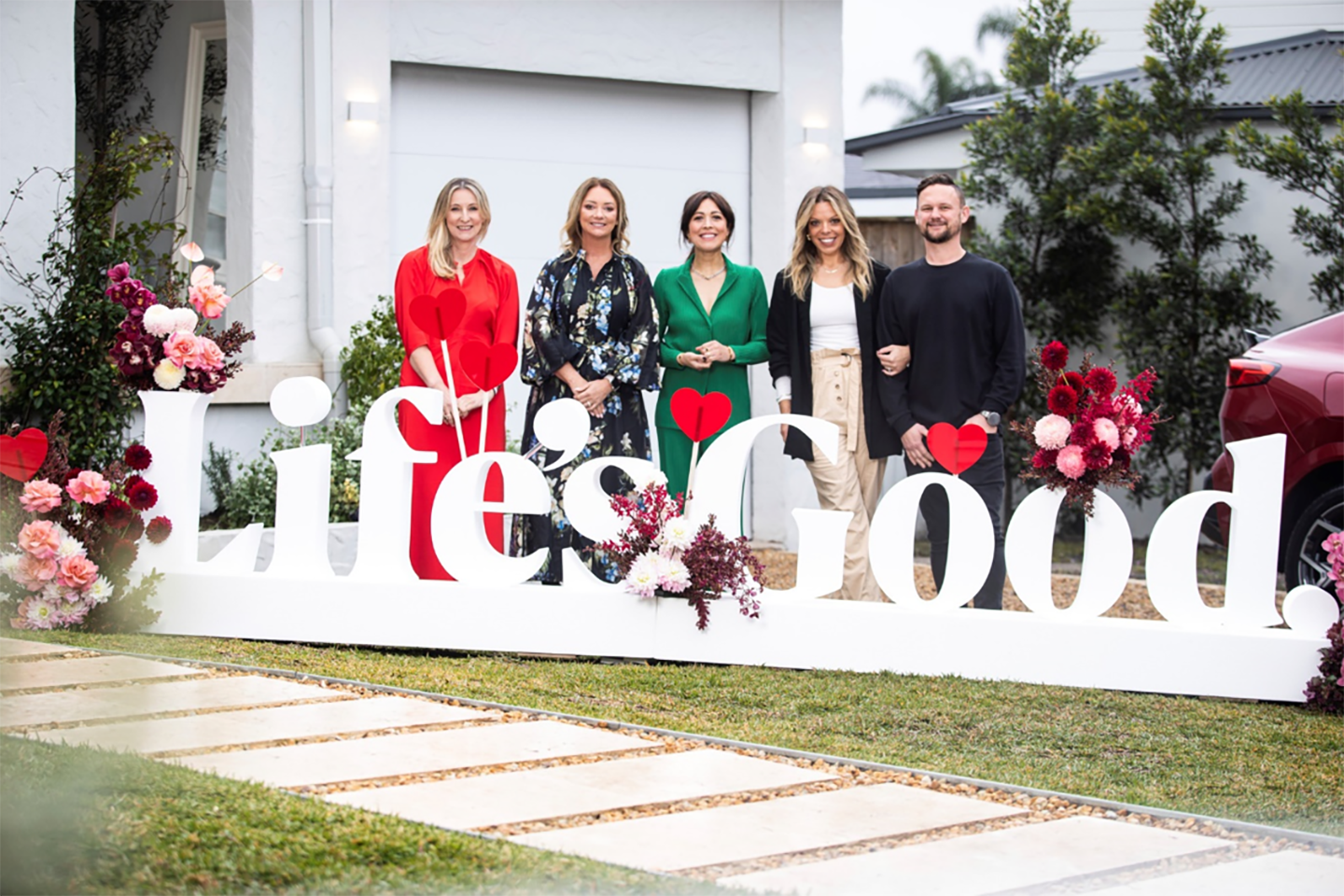 A picture of five people standing behind a Life's Good logo
