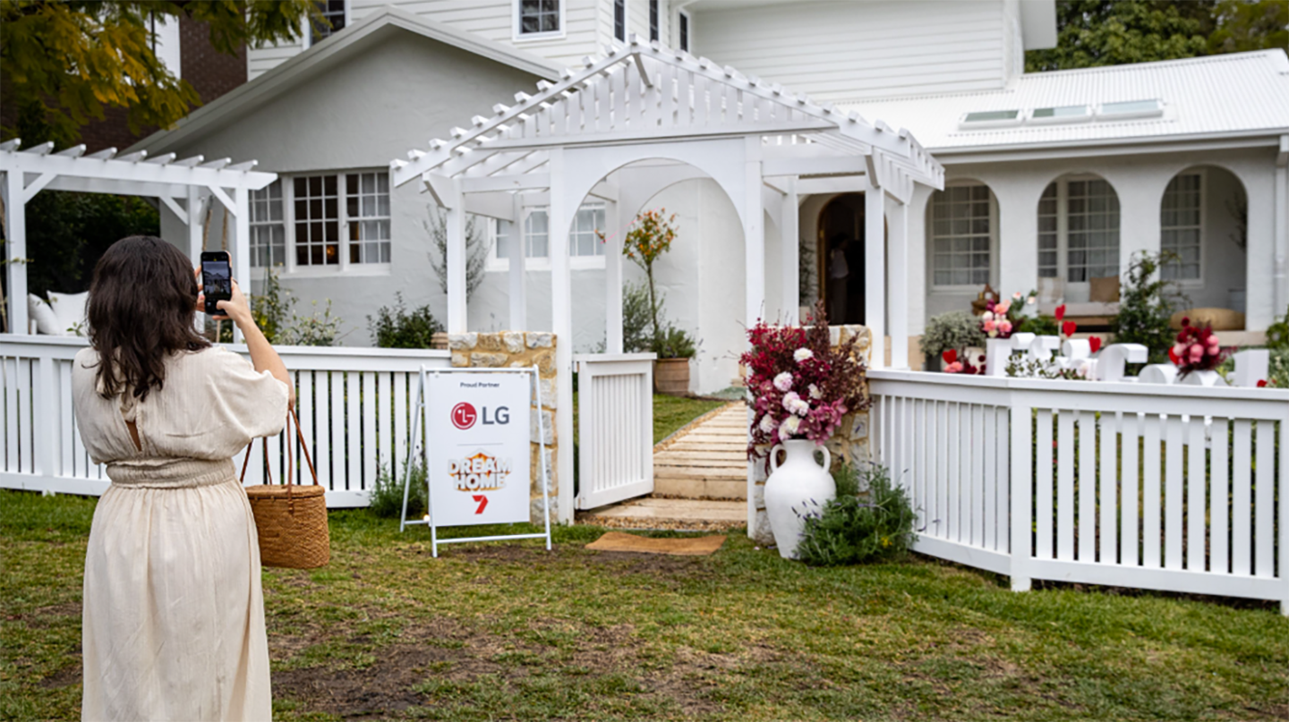 A picture of a woman taking a picture of the contestant's home at the event
