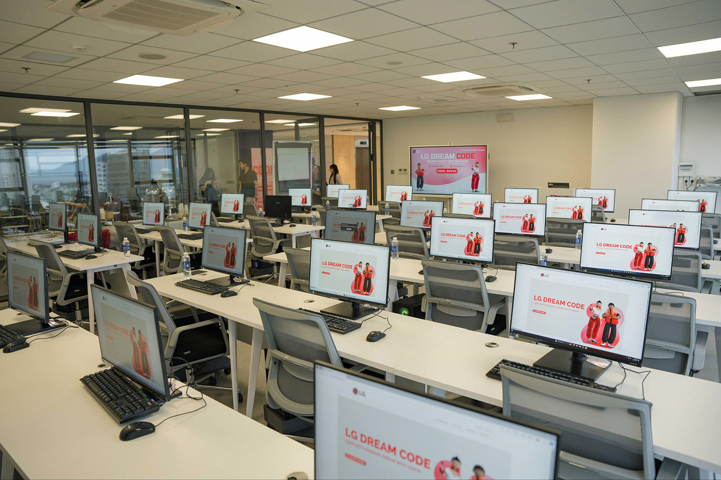 A photo of LG Dream Code program page shown on the screen of a number of computers in an empty computer lab