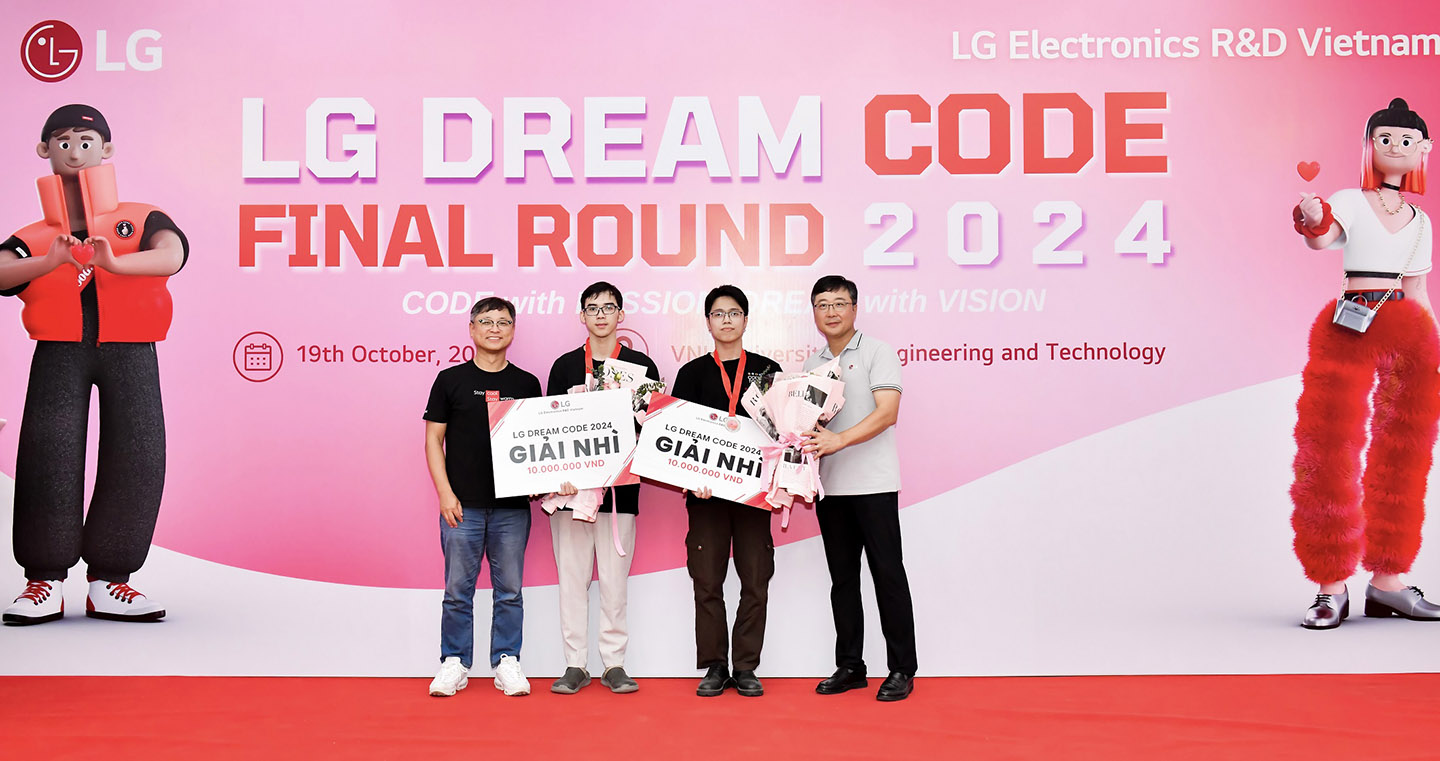 A photo of two winners from the final round of LG Dream Code 2024 and two LG officials smiling with their medals and prizes in front of the photo zone