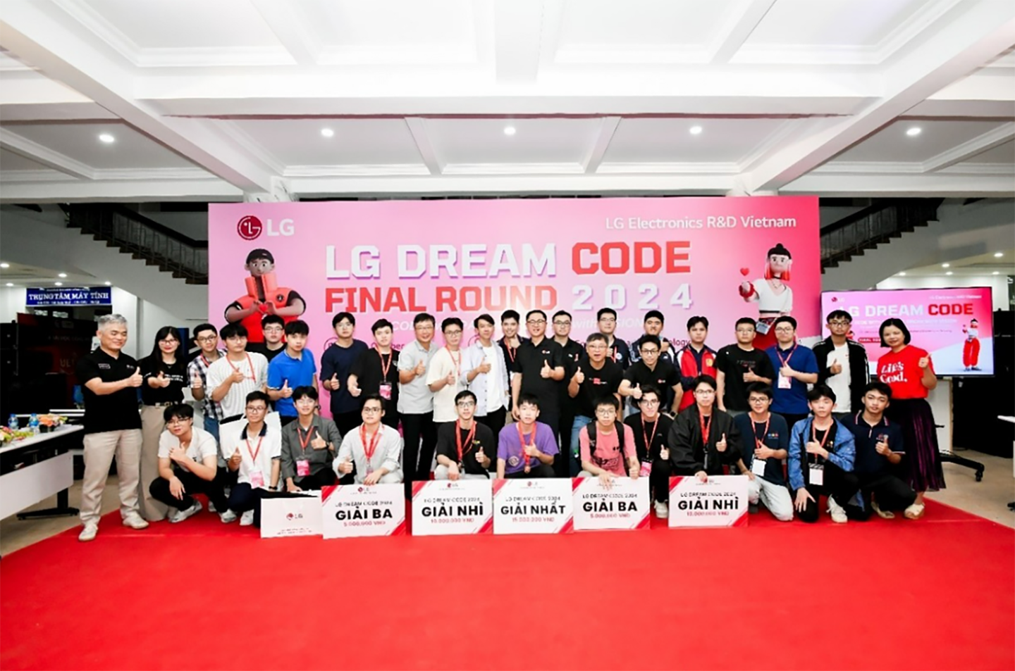 A group photo with students and experts who participated in LG Dream Code and LG officials at the red-carpeted photo zone