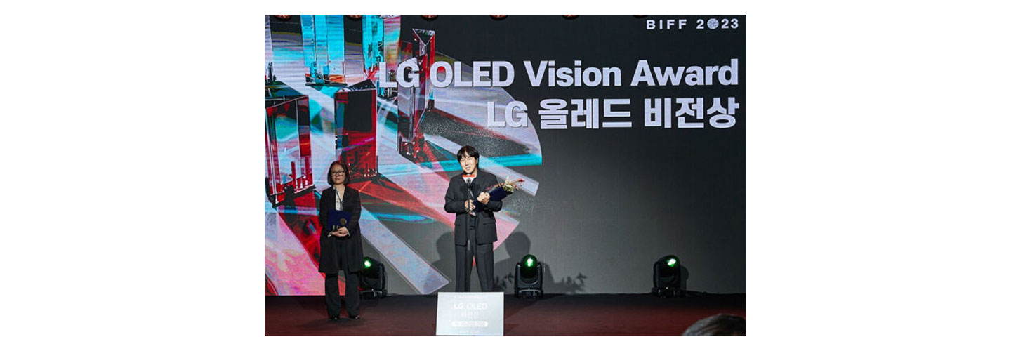 LG OLED Vision Award recipient Director Jeong Beom giving a speech while holding a trophy