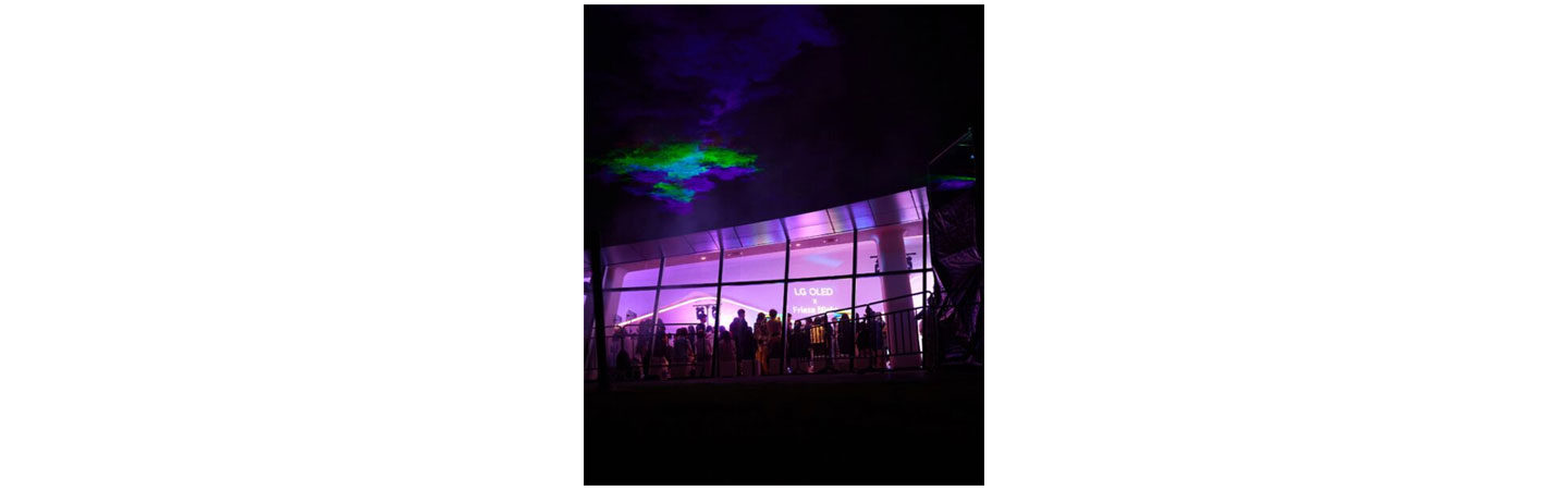 LG OLED X Frieze Night attendees reflected in the glass on the wall of Dongdaemun Design Plaza