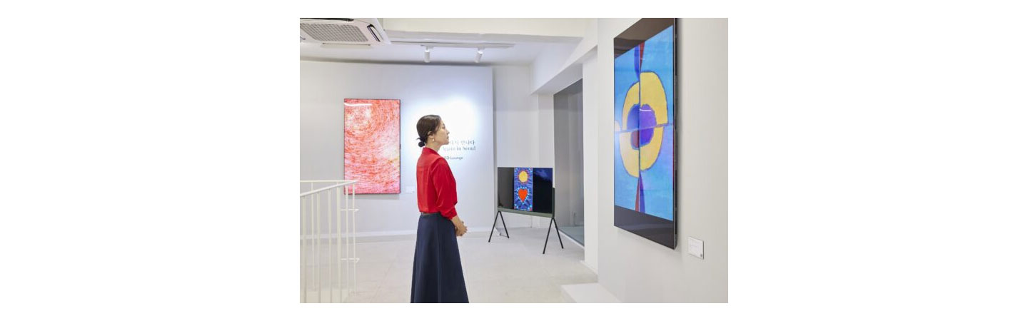 A woman in a red shirt admires the artwork on display at Frieze Seoul 2023
