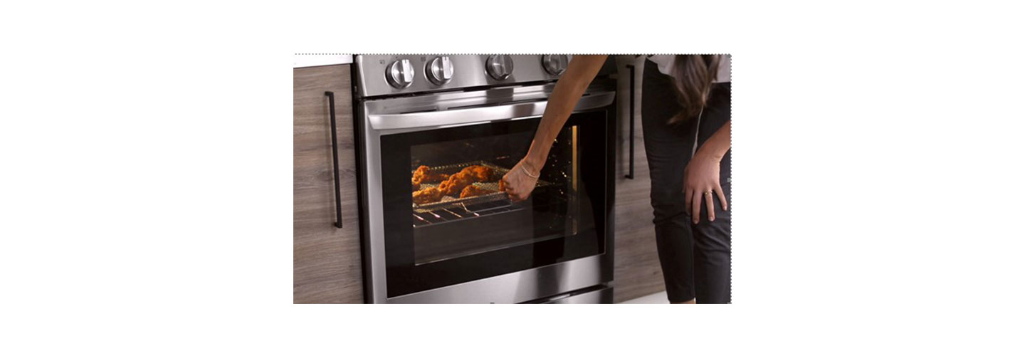 A woman knocks on the door of her LG smart oven via InstaView to check on her meal’s cooking progression