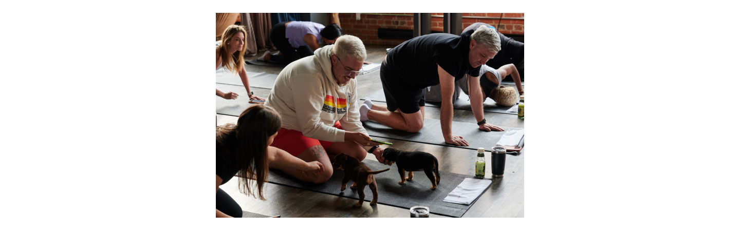 A participant playing with puppies during the yoga session