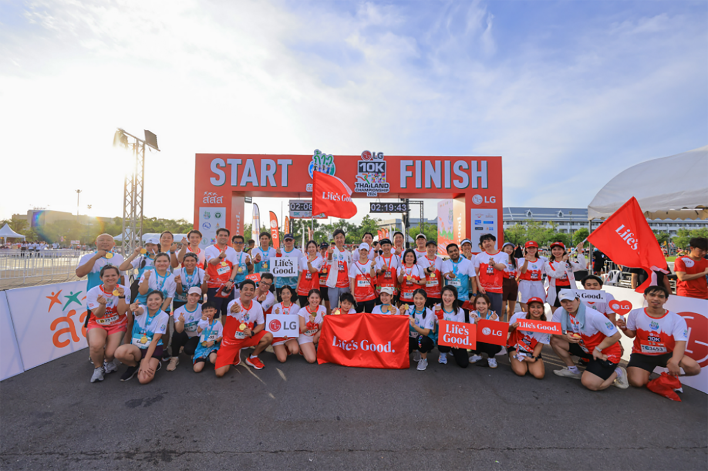 A group photo with Life's Good banners and placards at the start and finish line of the Kao Ta Jai 10K Thailand Championship 2024 Marathon
