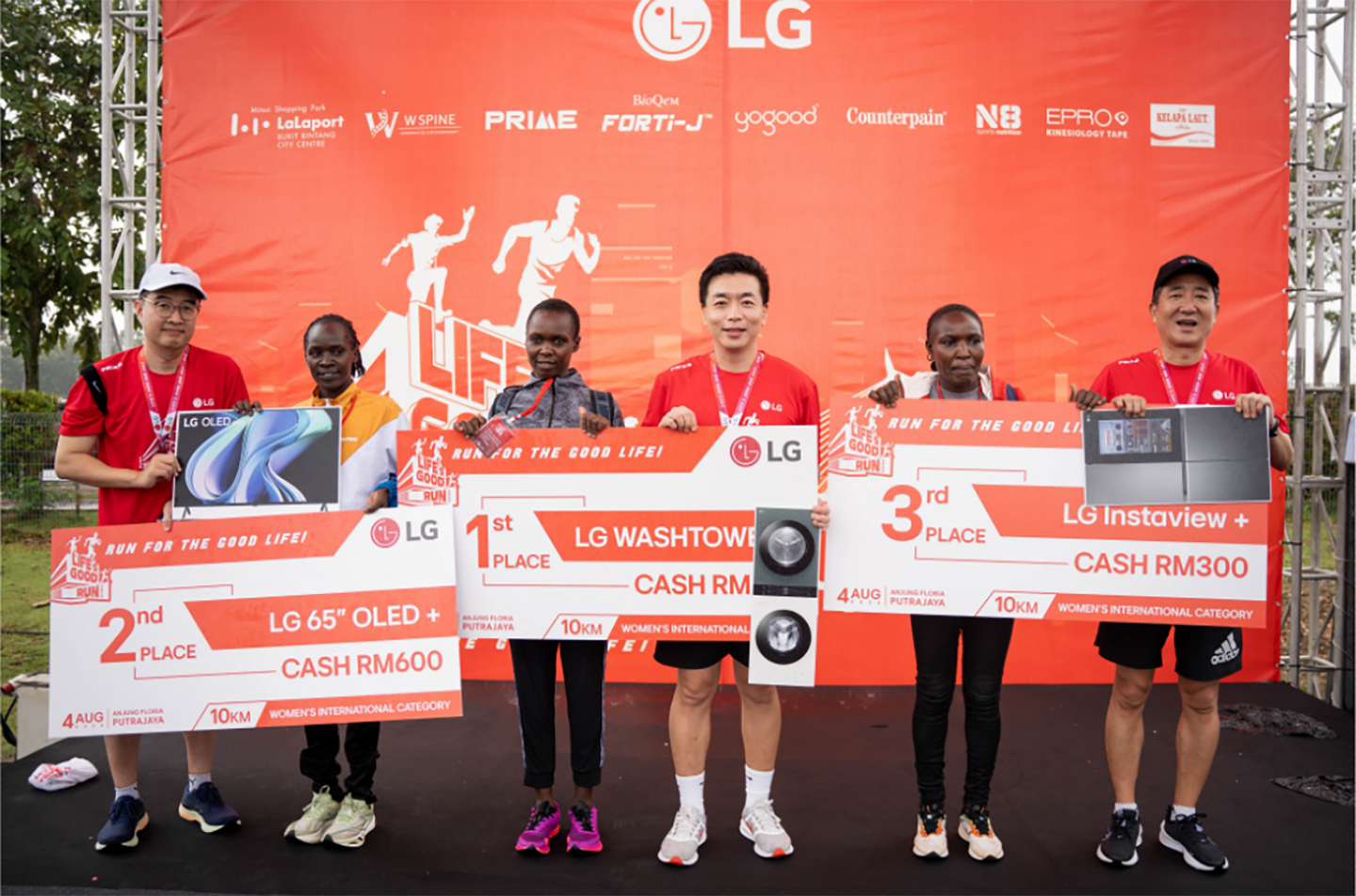 A photo of the 1st, 2nd, and 3rd place winners of the Malaysia Life's Good Run receiving their prizes and medals 