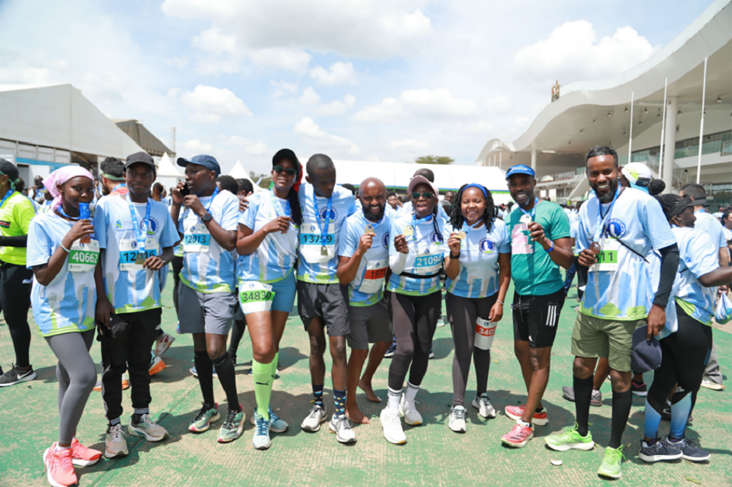 A photo of 10 people smiling and posing for a photo at the Standard Chartered Nairobi Marathon