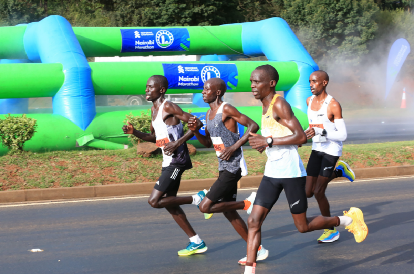 A photo of four participants in a marathon, running hard