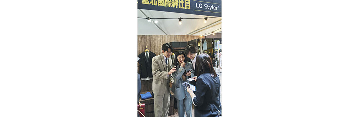Attendees of GQ Suit Walk having fun at LG booth taking polaroid pictures