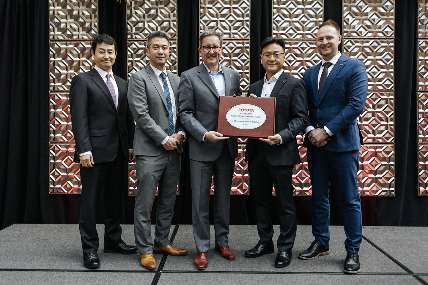 LG executives, including Brad Oh, President of LG Vehicle Solution USA (fourth from left), are pictured with Toyota executives alongside the 2024 Toyota 'Excellent Value Improvement Award'