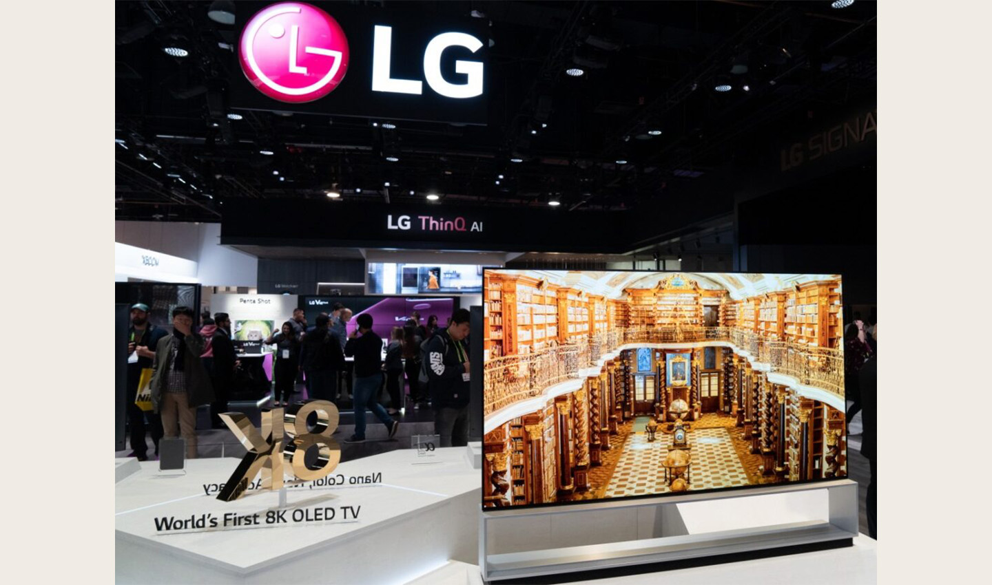 Front view of an LG 8K OLED TV set positioned on the right side of a promotional sign saying "World's First 8K OLED TV"