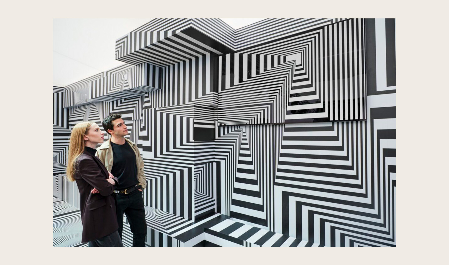 Two visitors taking a closer look at LG OLED-powered “Into the Maze” installation by the German artist, Tobias Rehberger