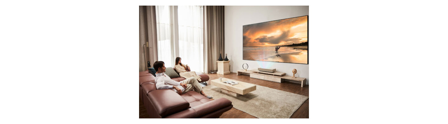 Use scenario of LG CineBeam – Two people are watching the projected screen in a living room
