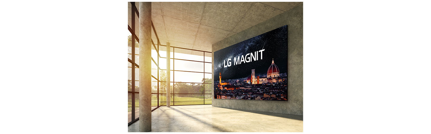 A modern interior space boasting natural light from its expansive windows has LG MAGNIT hanging on the wall, the new Micro LED signage solution displaying a beautiful, crystal-clear night scene of Italian city Florence