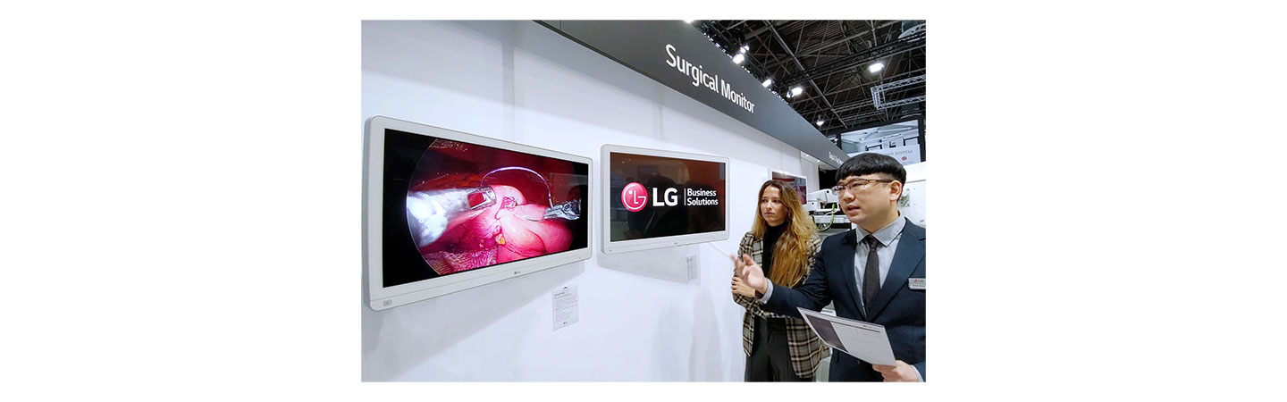 LG booth in MEDICA – A staff is introducing LG medical monitors to a visitor