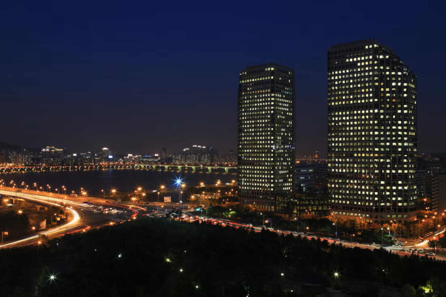 An aerial view displays a nighttime cityscape of the LG Twin Towers.