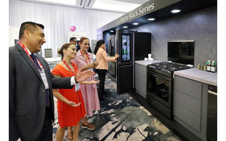 Delegates look at the SIGNATURE products at the booth.