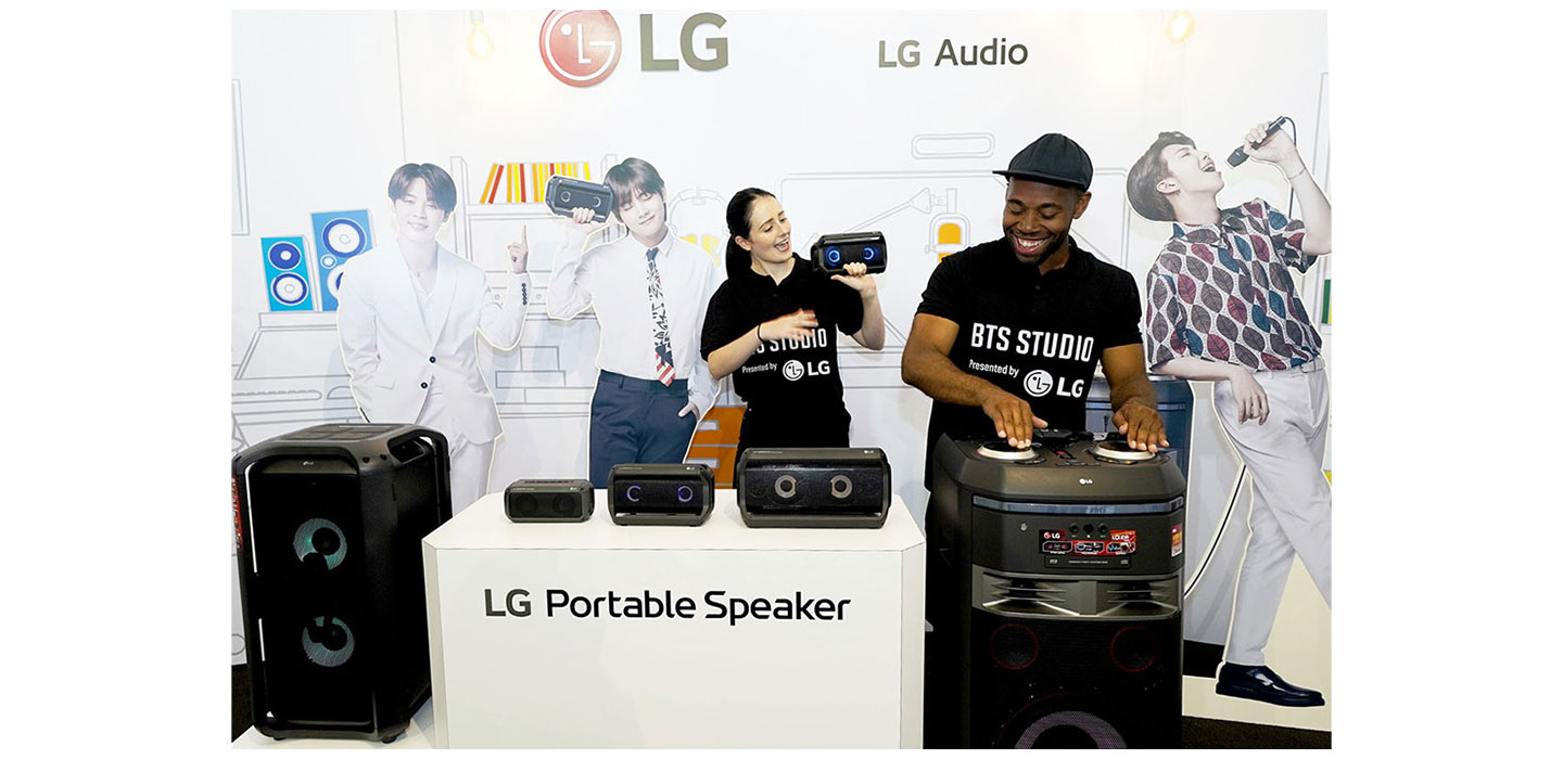 A man and woman both test LG’s speaker products at the BTS Studio Presented by LG.