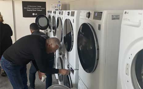 A man trying to use LG washer and dryer installed at free laundry facility that LG built to support victims of disastrous earthquake in Türkiye