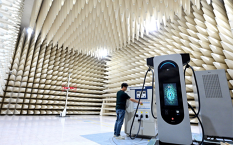 A photo of a man examining a machine connected to the LG EV charger