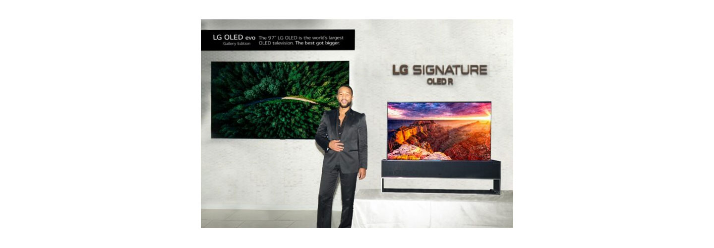 Singer John Legend posing in front of LG 97-inch G2 OLED evo TV and LG SIGNATURE OLED R TV at CEDIA Expo 2022