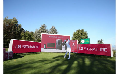 A golfer hits a ball right in front of the LG Signature signage.