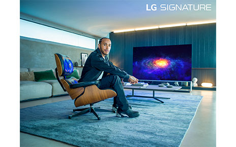 World Champion Lewis Hamilton, who has been appointed as a global ambassador for LG SIGNATURE, sitting in front of LG OLED TV as he poses for the camera