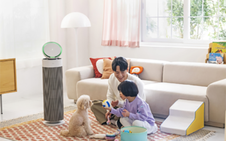 A photo of the LG PuriCare AeroBooster set up in a living room beside a family 