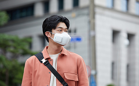 A man on a street wearing LG PuriCare™ wearable Air Purifier