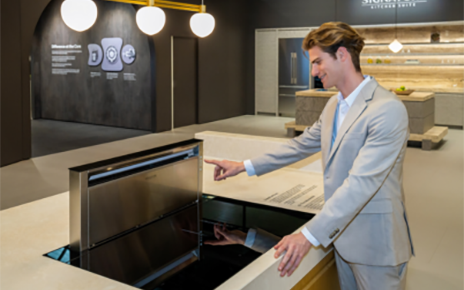 A photo of a man experiencing a free zone induction hob in the SIGNATURE KITCHEN SUITE Kitchen zone at Salone del Mobile 