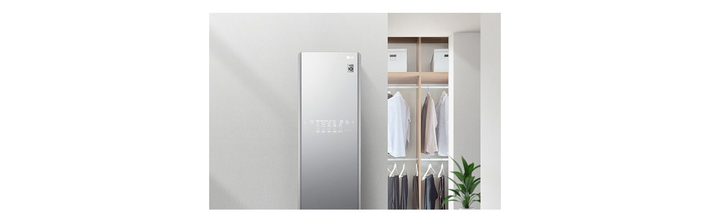 LG Styler Black Tinted Mirror Glass Door in a home with clothes hanging on a closet in the background