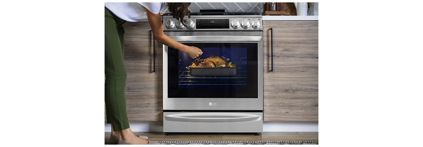 A woman is knocking on the glass window of the oven of InstaView® Range to see inside