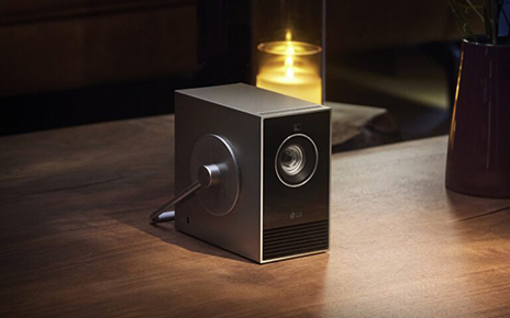 LG CineBeam Qube placed next to a candle