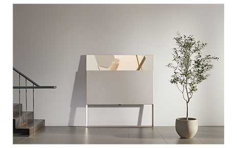 LG’s beige Objet TV leaning against the wall as it displays the date and time in its Line View mode.