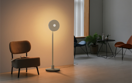 In a living room with a couple of chairs lie LG Projector PF600U lighting a wall, setting a warm tone to the room