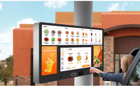A woman interacting with an outdoor digital menu board